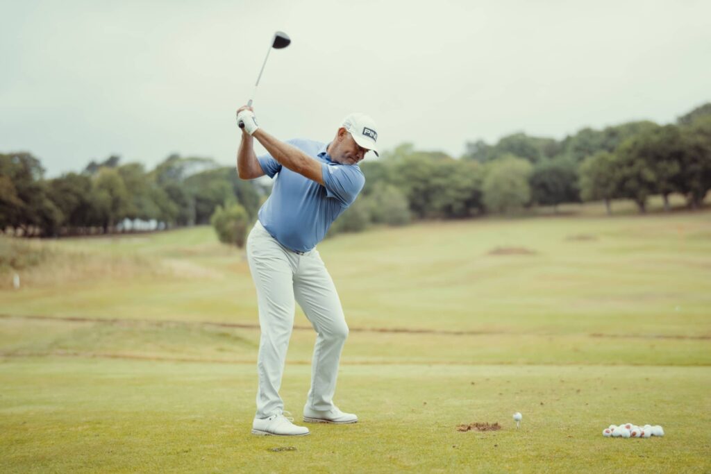 Lee Westwood hits fairway wood on the golf course