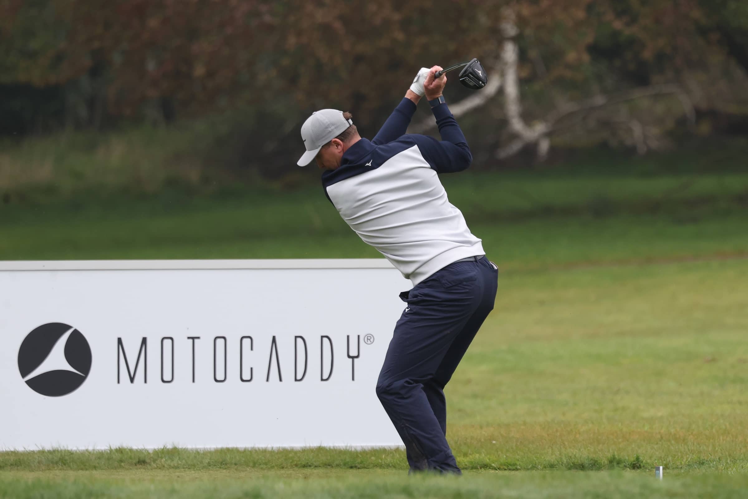 OJ Farrell strikes ball with Motocaddy sign in background