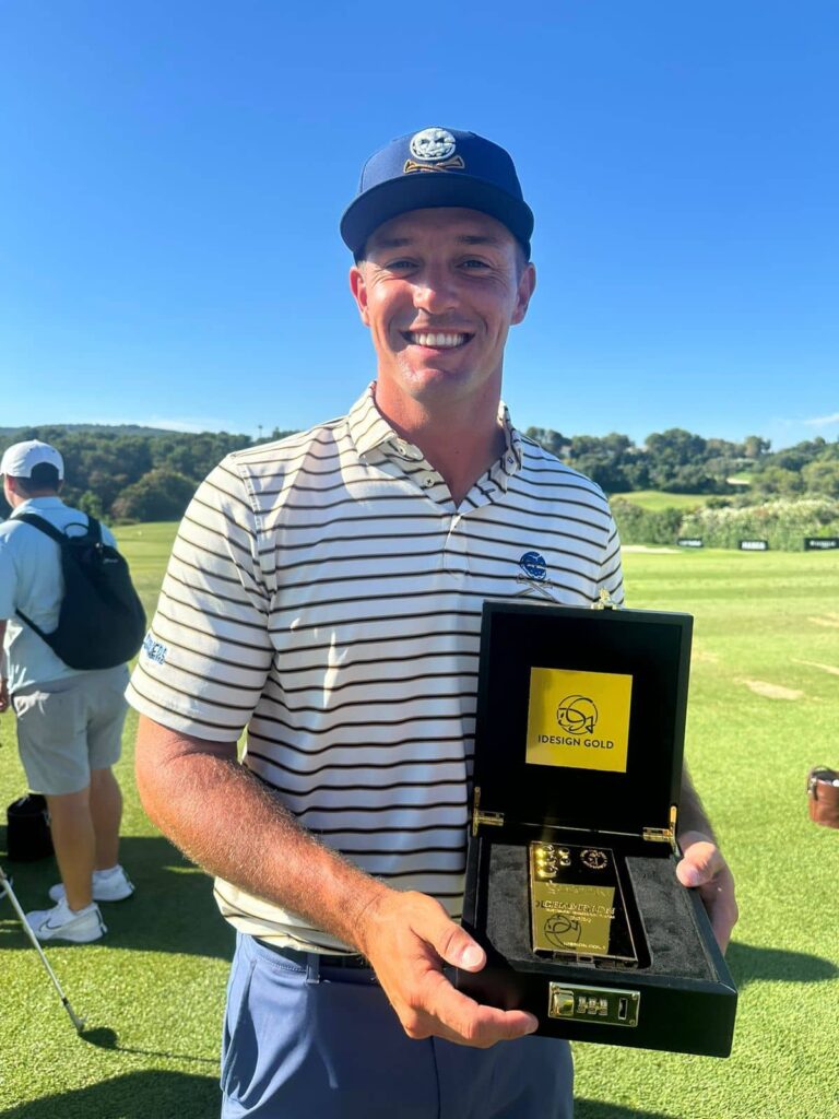 Bryson DeChambeau holding onto his gold encased mobile phone