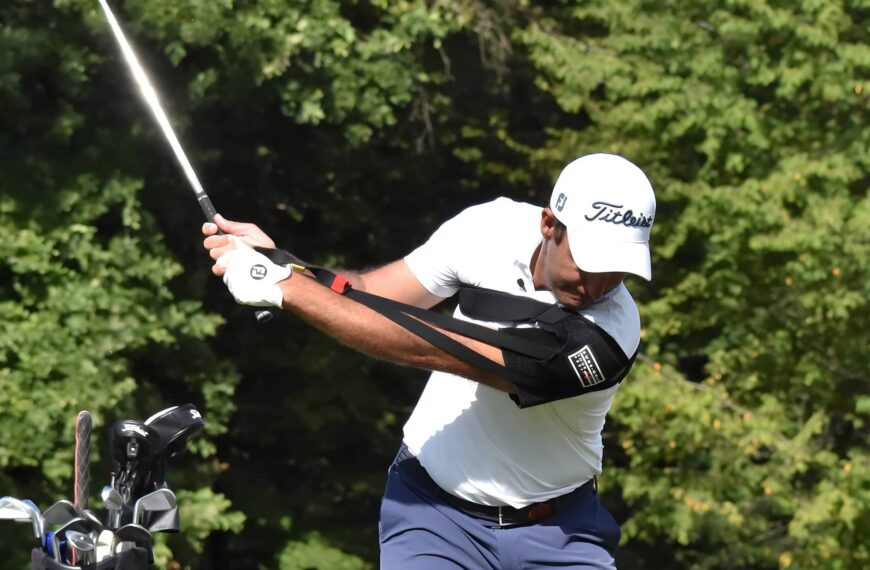 Golfer wearing training aid on arm