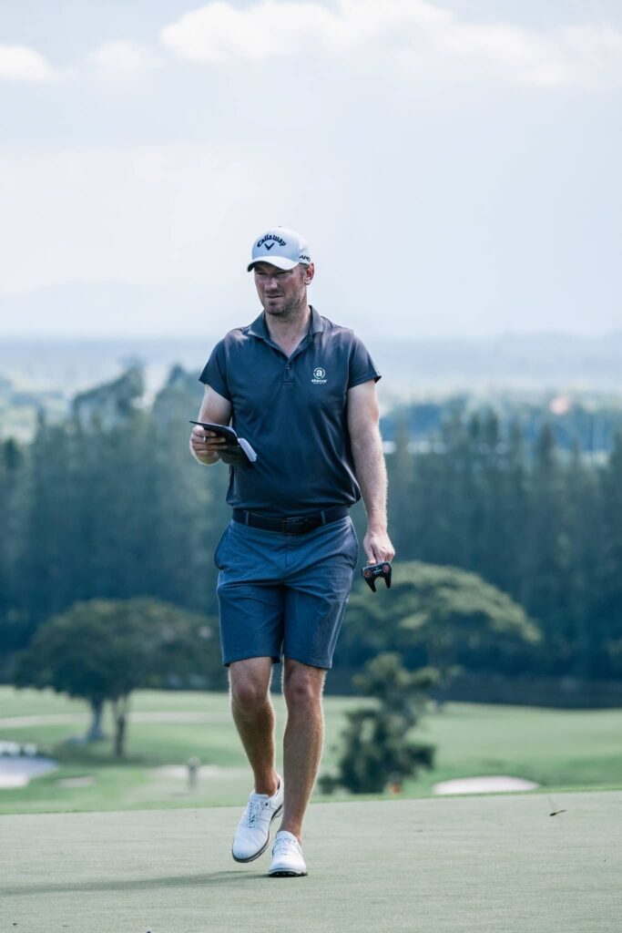 Former Ryder Cup player Chris Wood reads his yardage book in a practice round ahead of the Black Mountain Championship in Hua Hin