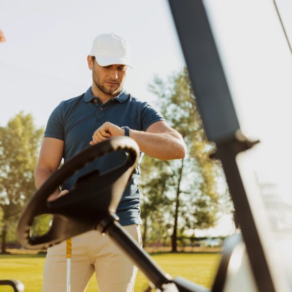 Young male golfer looking at a wristwatch