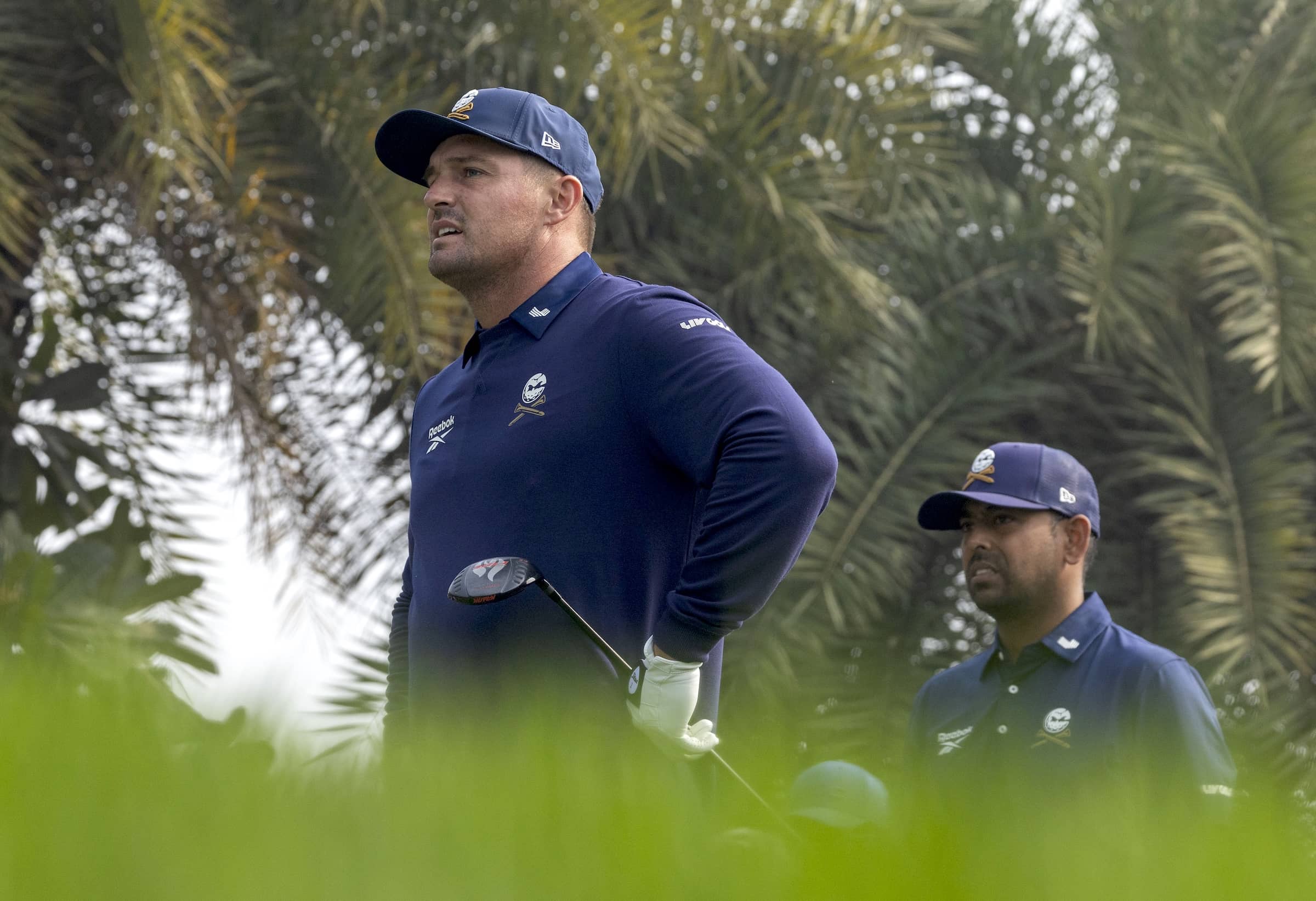 Bryson DeChambeau and Anirban Lahiri watch a tee shot during the final round at International Series India presented by DLF, the opening event on the 2025 schedule. © Asian Tour.