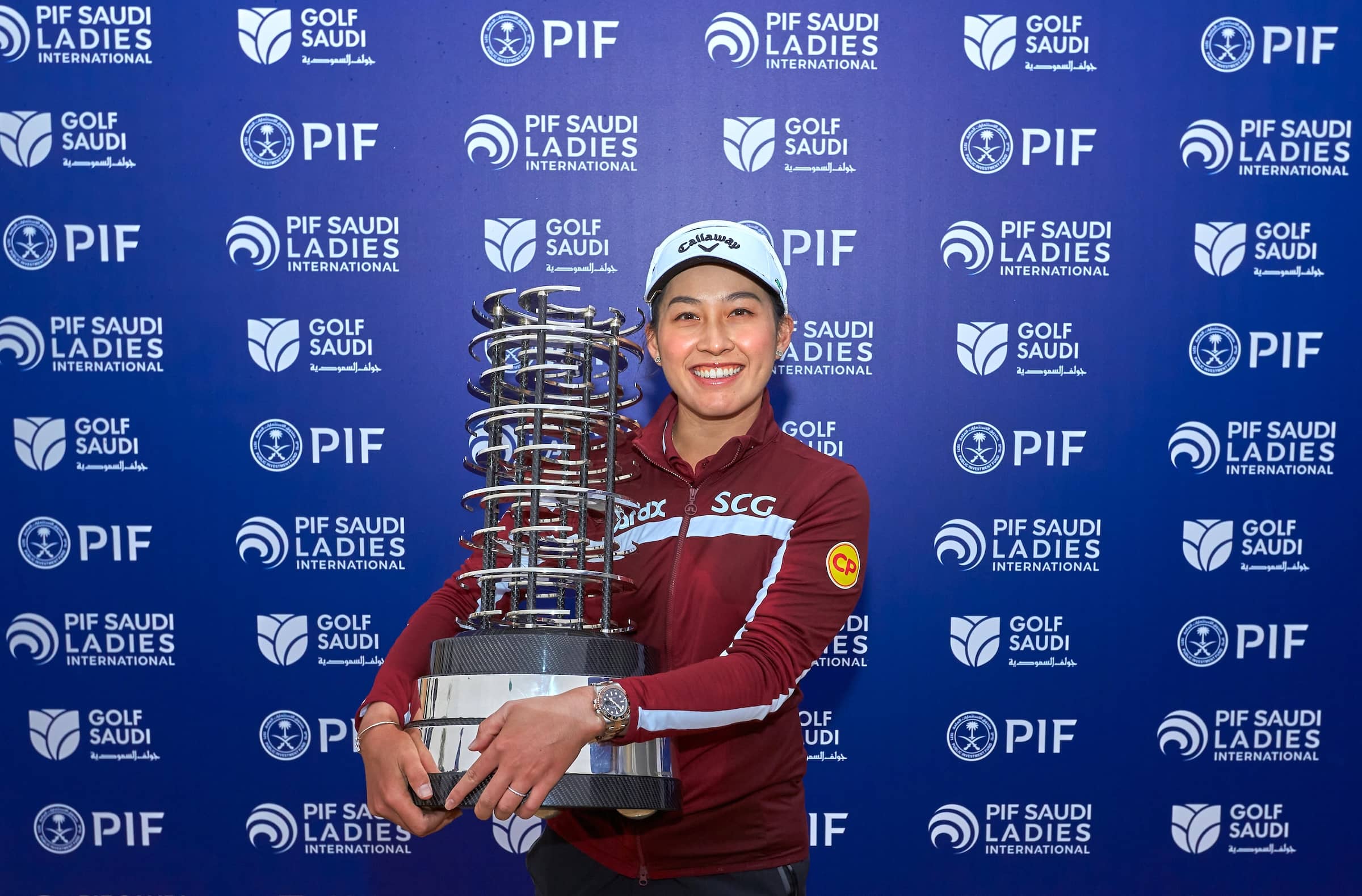 Jeeno Thitikul scoops up the trophy after three days at Riyadh Golf Club