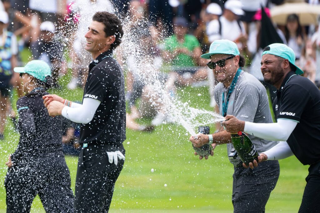 Captain Joaquín Niemann of Torque GC celebrates gets sprayed with champagne from teammate Sebastián Muñoz of Torque GC on the 18th green after the final round of LIV Golf Singapore at Sentosa Golf Club Sentosa, Singapore.