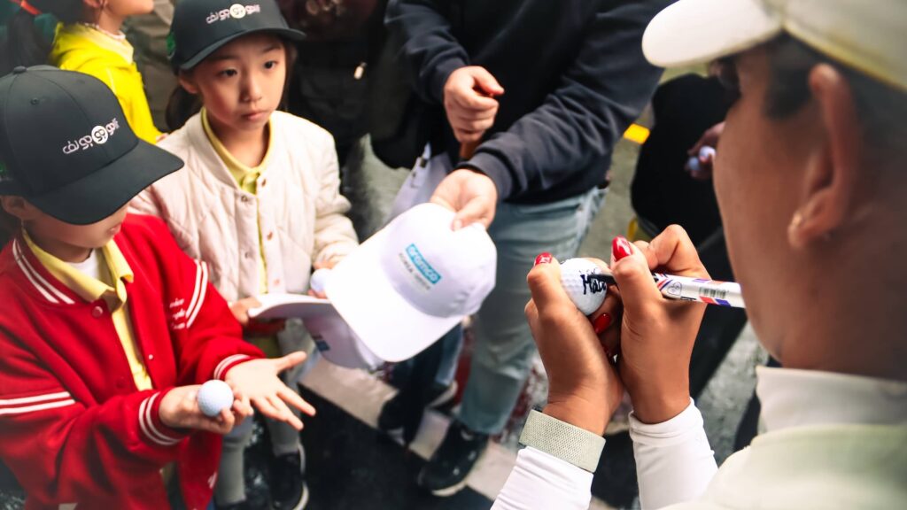 Children from the First Tee Korea initiative receiving autographs from player Maha Haddioui at the Aramco Korea Championship, the second of five events on the PIF Global Series in 2025.